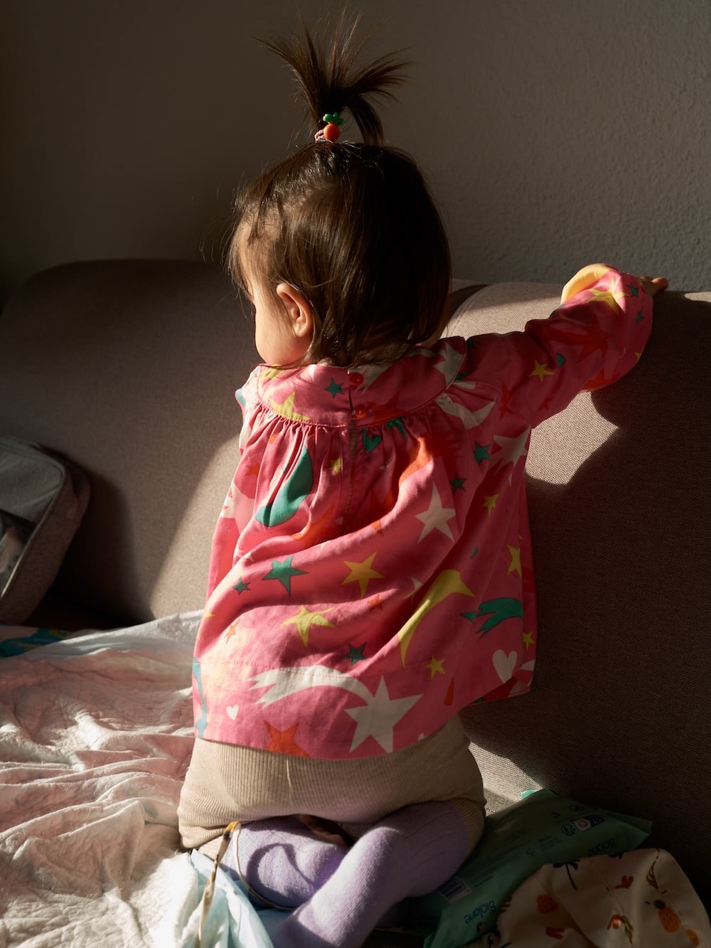 Untitled (Ajaccio) (2023) Ajaccio, Corsica: a child sits on a sofa, bathed in a golden light, facing away from the camera (2023)